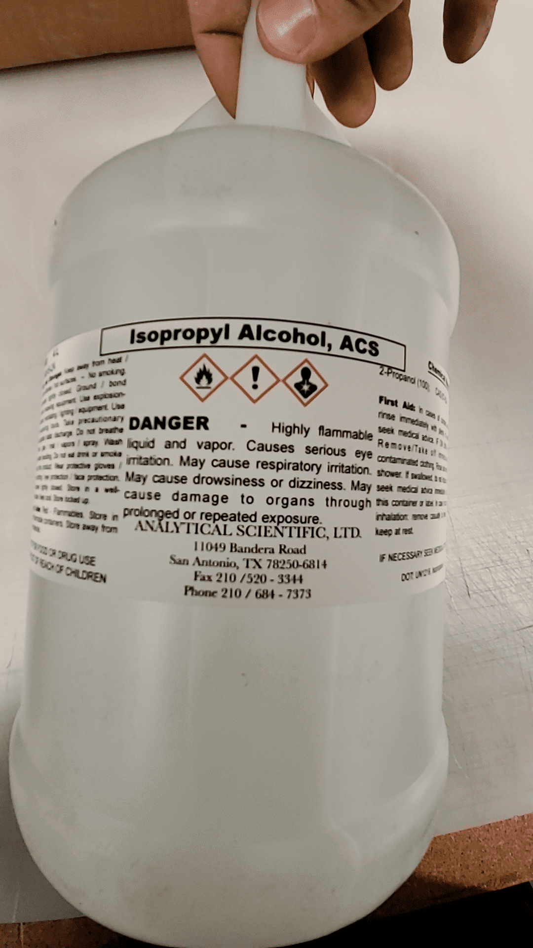 White 4L bottle of Isopropyl Alcohol ACS grade with warning labels and usage information.